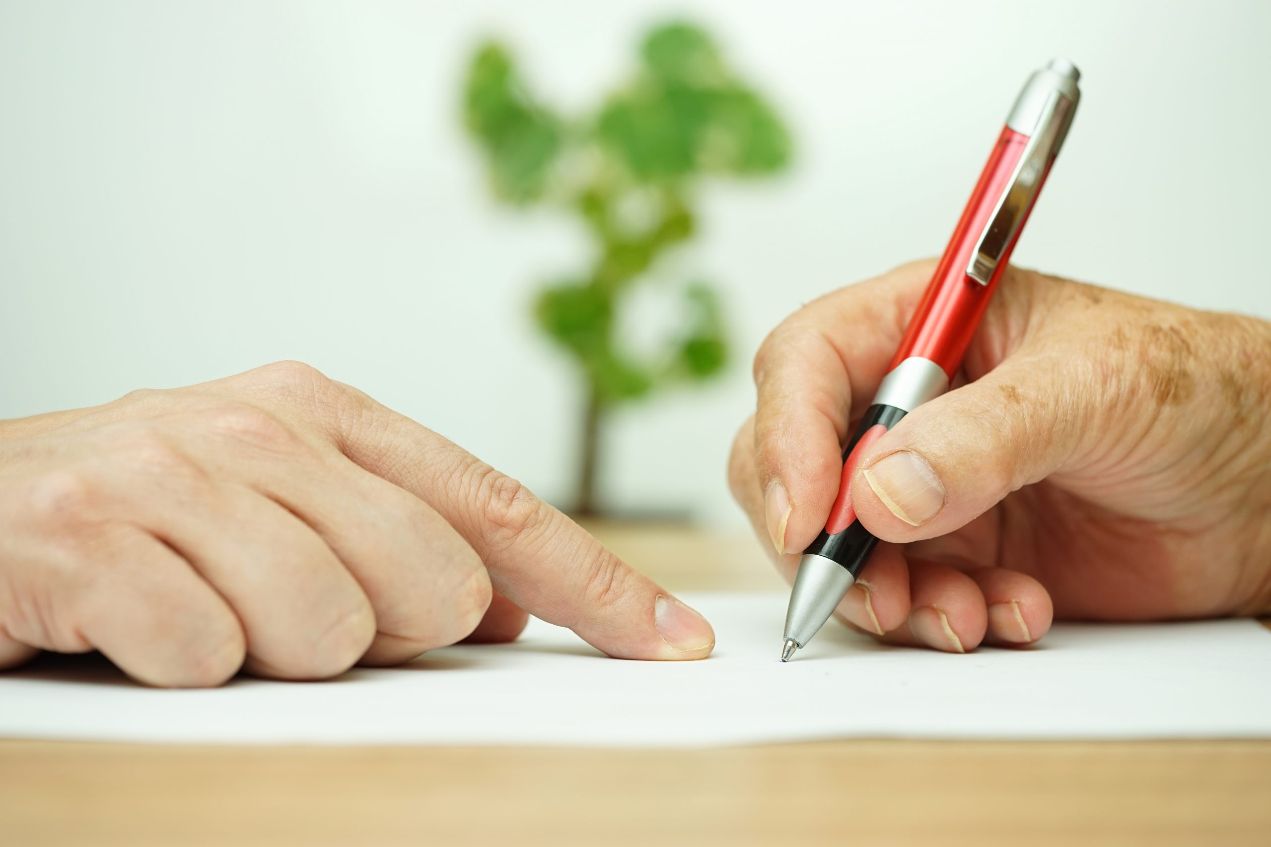 Hand of young adult pointing elderly person where to sign