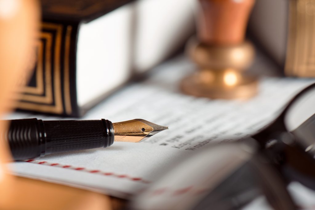 Füllfederhalter auf notariellem Dokument mit Siegel als Symbol für Testament und Pflichtteil